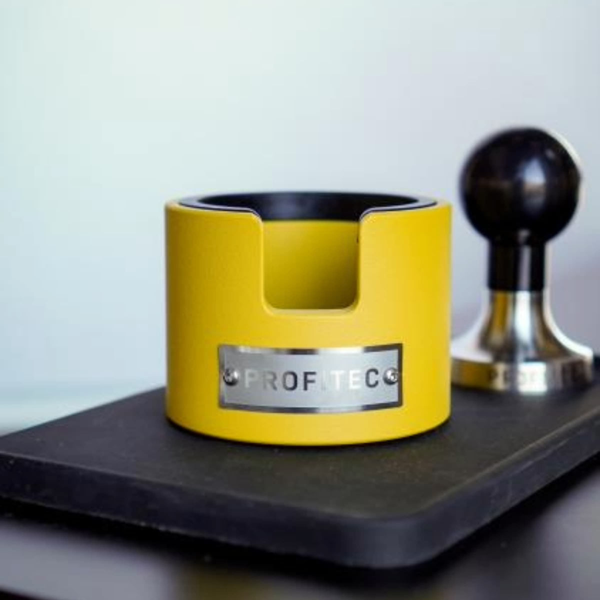Yellow Profitec tamping station with profitec tamper